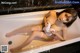A woman sitting in a bathtub holding a towel.