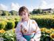 A woman in a kimono standing in a field of sunflowers.