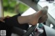 A woman's feet sticking out the steering wheel of a car.