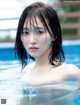 A woman in a swimming pool with wet hair.